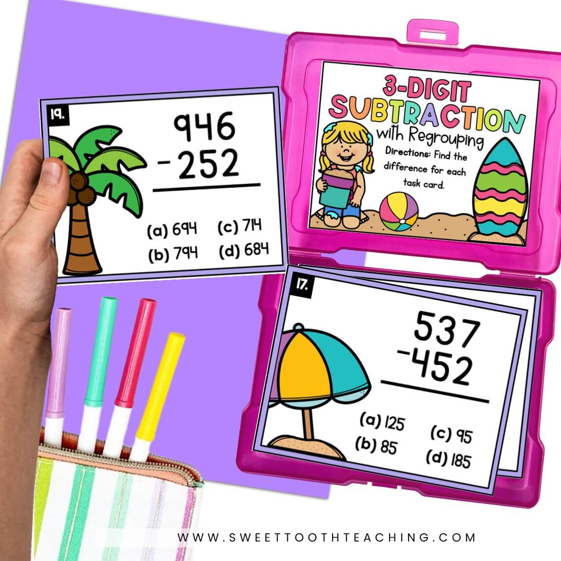 Student holds subtraction task cards with tropical clipart; 3-digit regrouping set, classroom math center, pink storage case, markers.