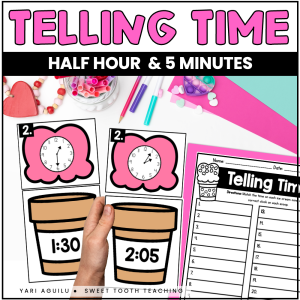 Student hand displays two telling time cards (1:30 & 2:05), with classroom supplies—perfect math center or teaching clock activity.